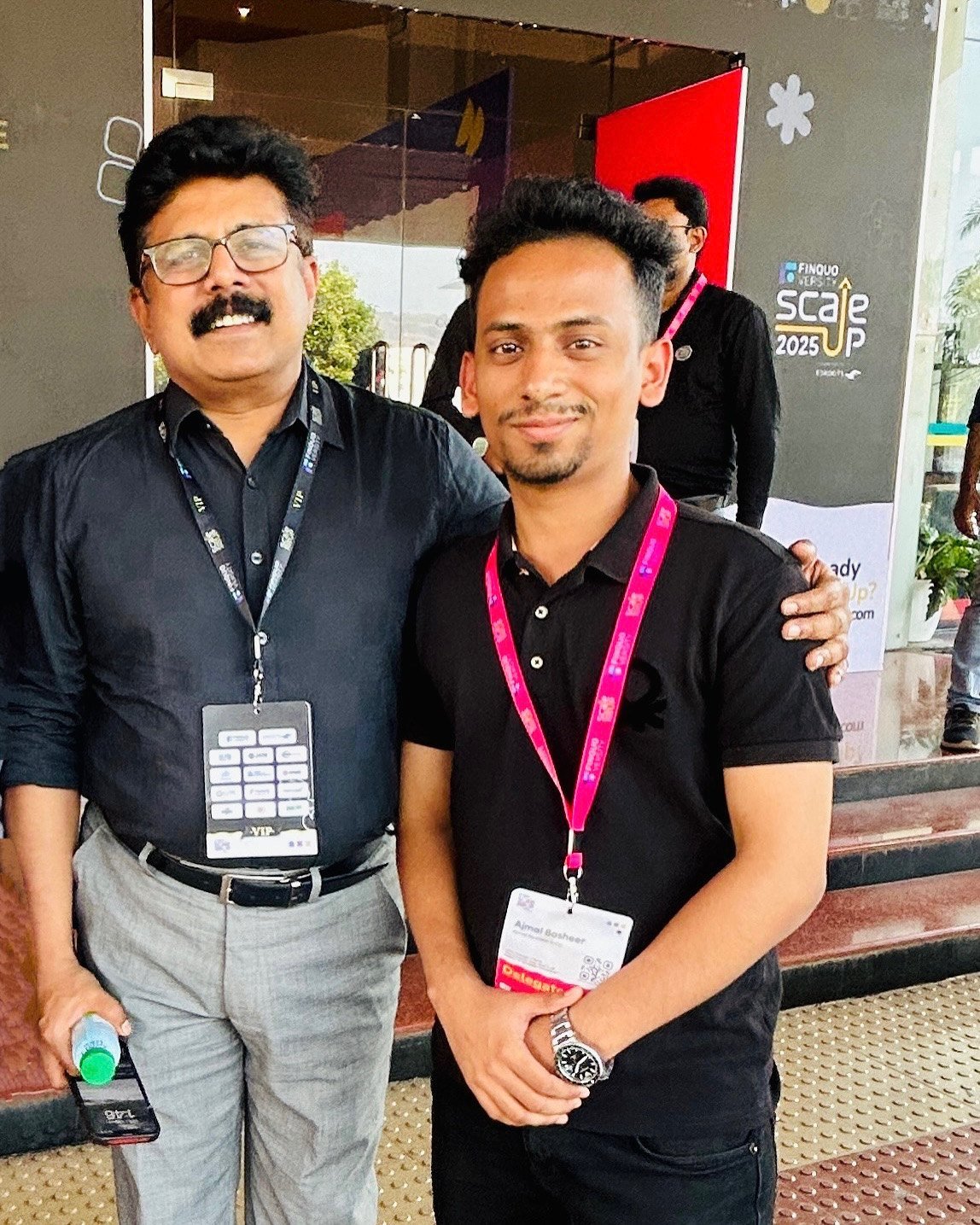 Ajmal Basheer in a delegate lanyard, standing arm-in-arm with a VIP guest at the Scaleup 2025 venue