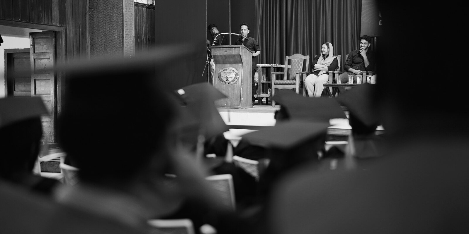Ajmal Basheer speaking from a podium to a graduating class