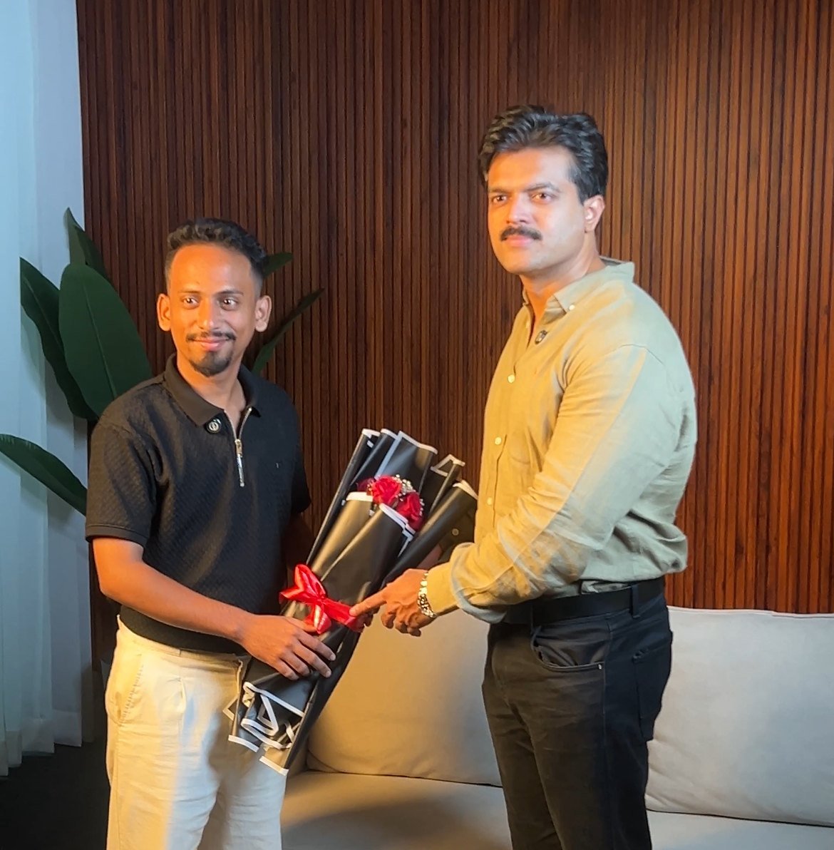 Ajmal Basheer welcoming a guest to The Job Show studio with a bouquet of red roses