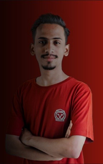 Ajmal Basheer in a red Stoa T-shirt, arms crossed, against a dark red background