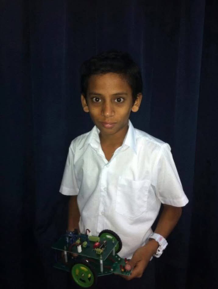 Ajmal Basheer as a boy in a white school shirt, holding the line-following robot he built