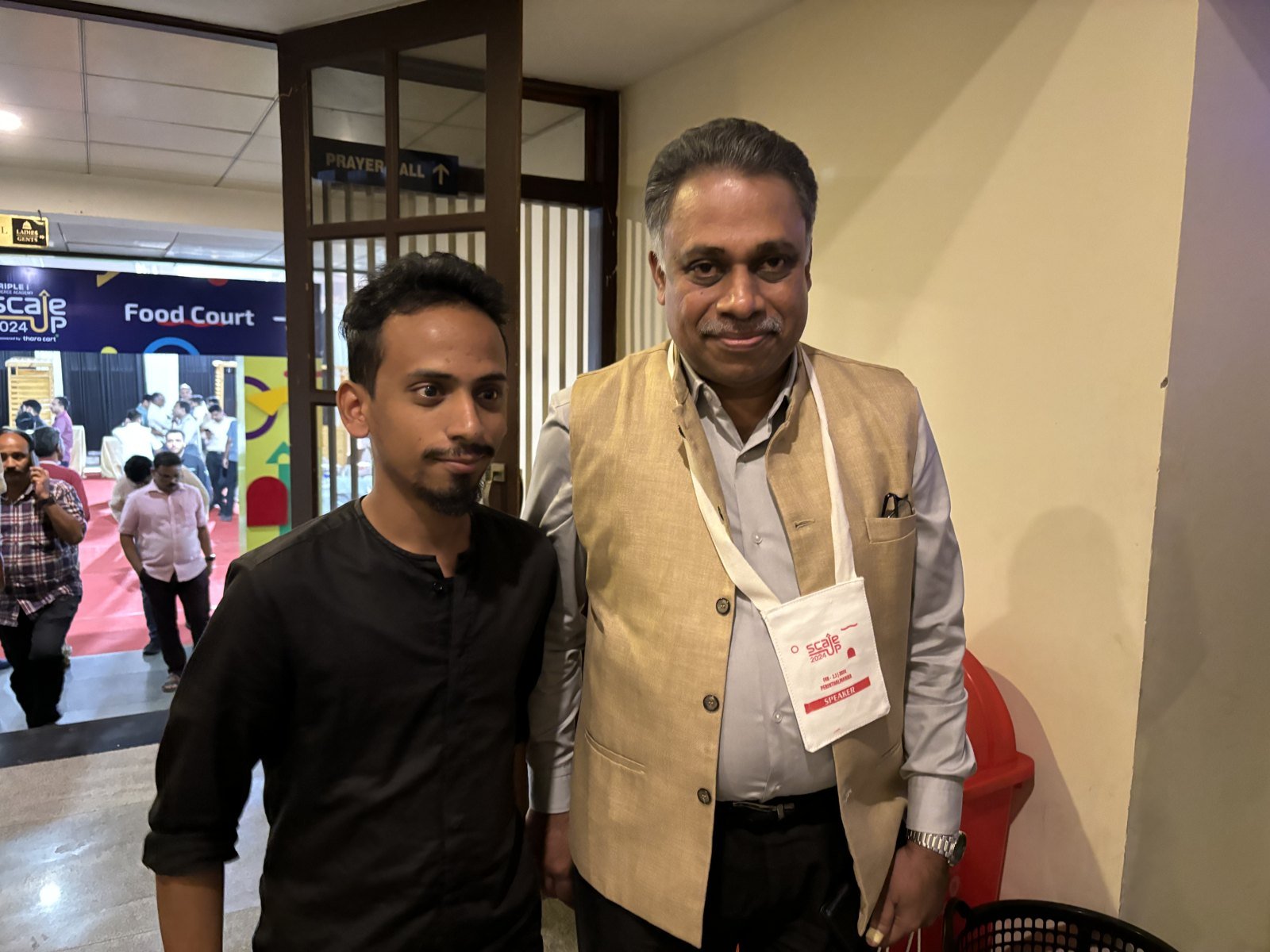 Ajmal Basheer with Dr. Saji Gopinath, wearing a Scaleup 2024 speaker badge, at the event venue