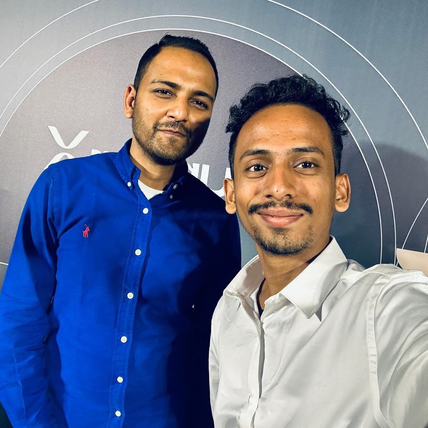 Ajmal Basheer taking a selfie with Vaibhav Vardhan, Co-founder and CEO of Inc42 Media, in front of a dark event backdrop